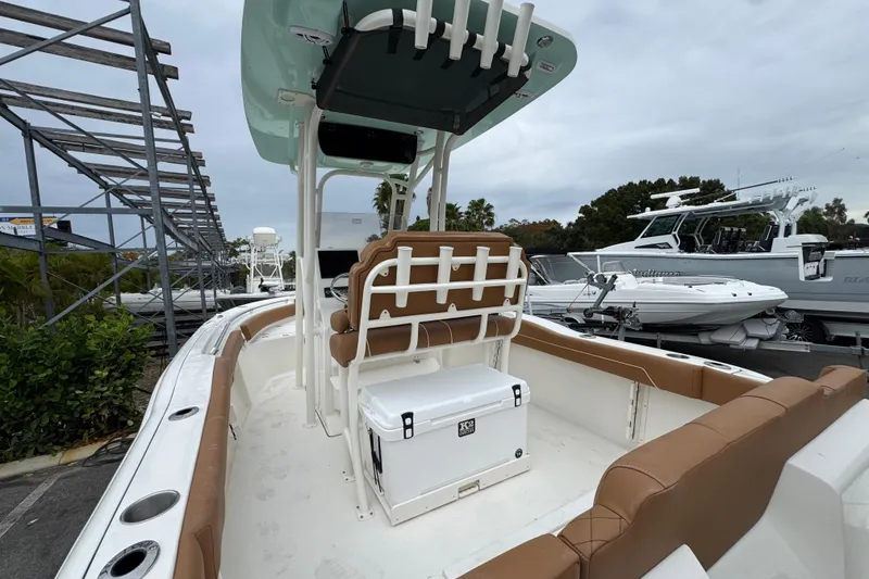 Slide: The Image of 2026 Key West 219 FS boat with tan seating and white deck, docked outdoors. - 12