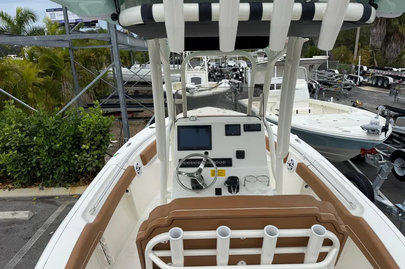 Slide: The Image of 2026 Key West 219 FS boat interior with steering console and seating, parked outdoors. - 14