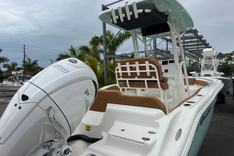 Slide: The Image of 2026 Key West 219 FS boat with Yamaha engine, docked under cloudy skies. - 6