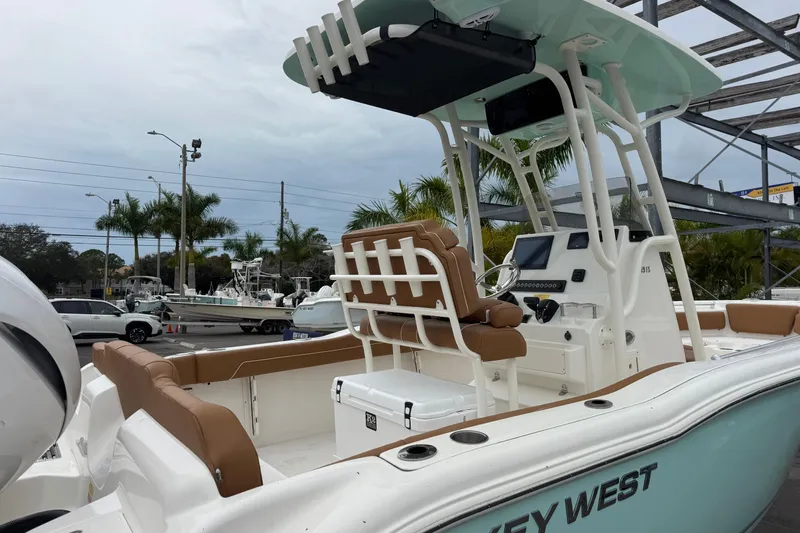 Slide: The Image of 2026 Key West 219 FS boat with tan seating and modern console, docked outdoors. - 8
