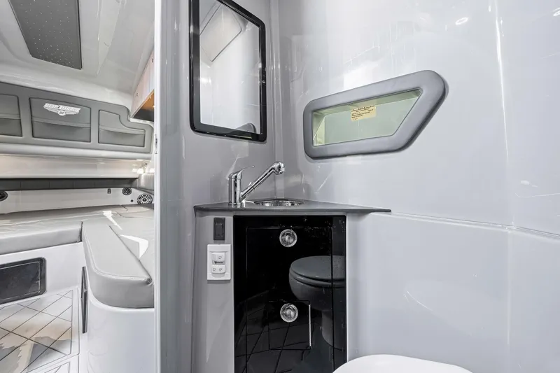 Slide: The Image of Interior of 2026 Deep Impact 499 Sport boat featuring sleek bathroom and seating area. - 27