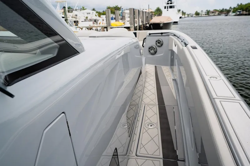 Slide: The Image of 2026 Deep Impact 499 Sport boat, sleek design, docked by the water. - 35