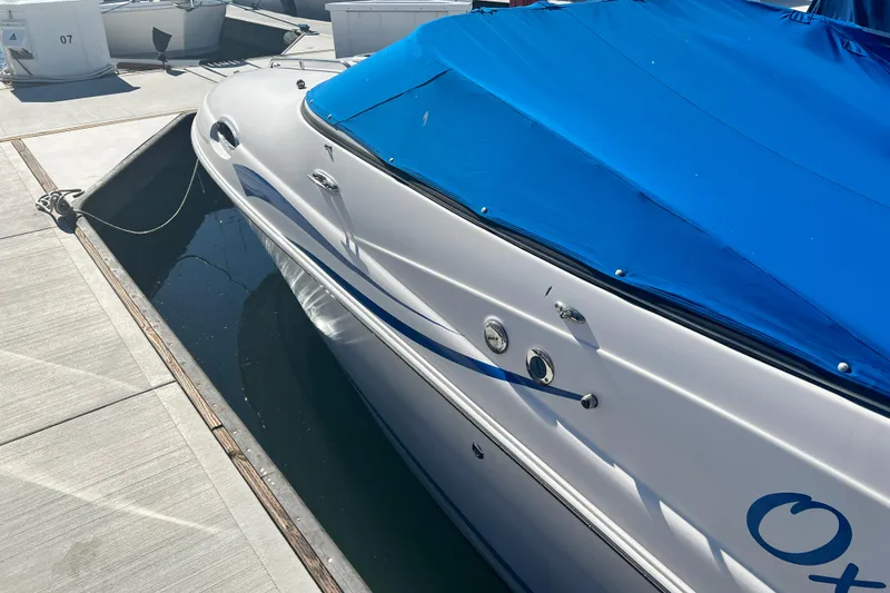 Slide: The Image of 2006 Regal Marine 2650 Cuddy boat docked with blue cover. - 7