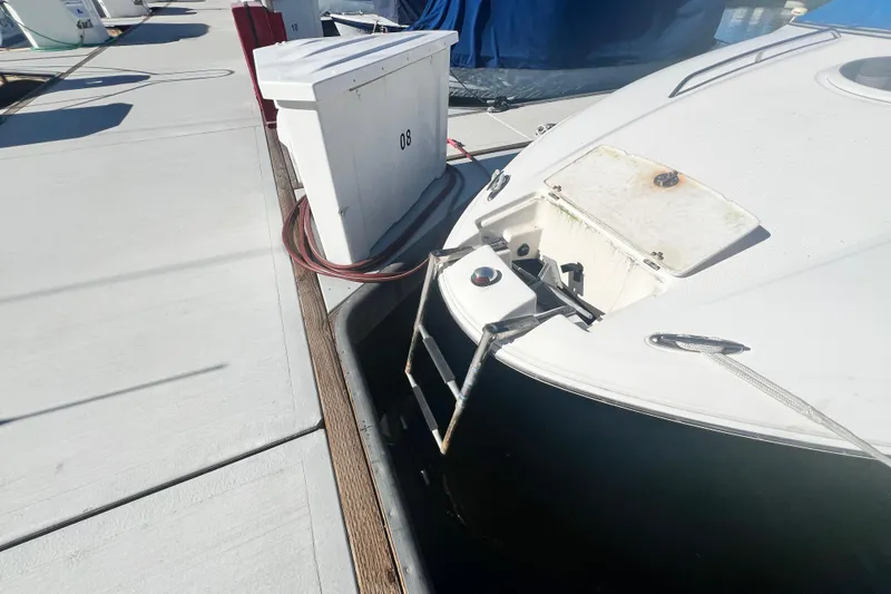 Slide: The Image of 2006 Regal Marine 2650 Cuddy boat docked with ladder and storage compartment visible. - 8