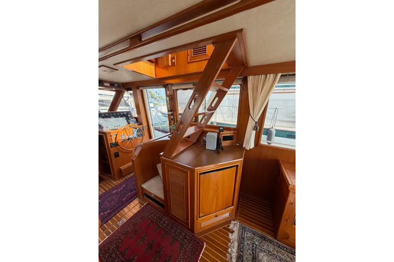 Slide: The Image of Interior of 1988 Offshore Yachts 48 Sedan, featuring wooden helm and staircase. - 28