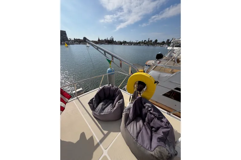 Slide: The Image of 1988 Offshore Yachts 48 Sedan deck with bean bags and waterfront view. - 38