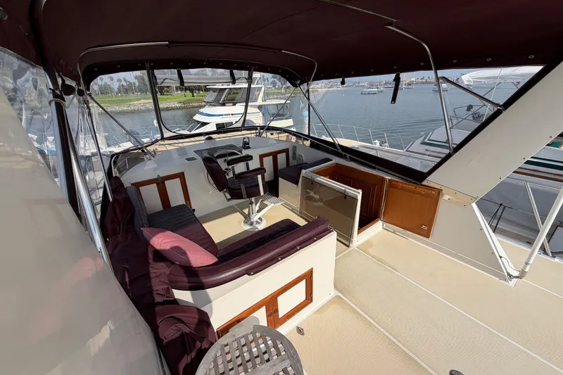 Slide: The Image of 1988 Offshore Yachts 48 Sedan interior with seating and helm, docked at marina. - 39