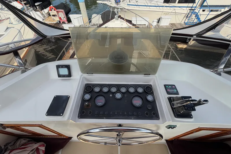 Slide: The Image of Helm of 1988 Offshore Yachts 48 Sedan with gauges and controls, docked at marina. - 42