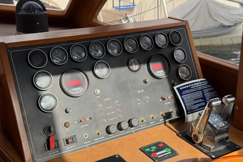 Slide: The Image of Control panel of a 1988 Offshore Yachts 48 Sedan with gauges and throttle levers. - 49