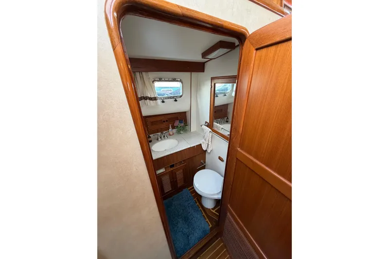 Slide: The Image of Bathroom interior of 1988 Offshore Yachts 48 Sedan, featuring wood accents and nautical decor. - 60