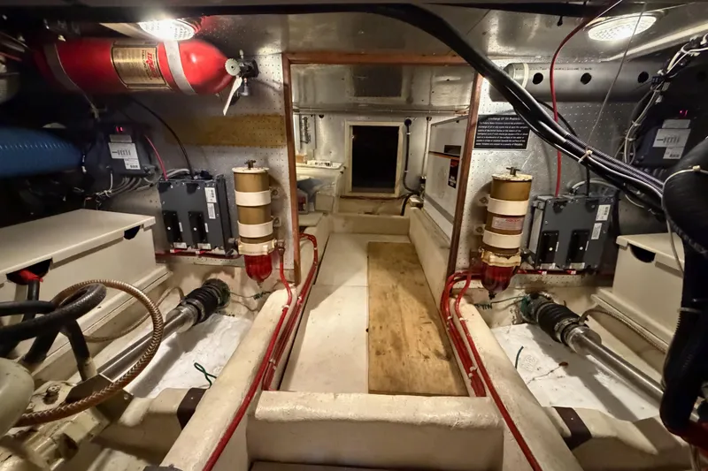 Slide: The Image of Engine room of 1988 Offshore Yachts 48 Sedan, featuring mechanical components and wiring. - 78