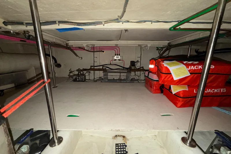 Slide: The Image of 1988 Offshore Yachts 48 Sedan interior storage with life jackets and equipment. - 83