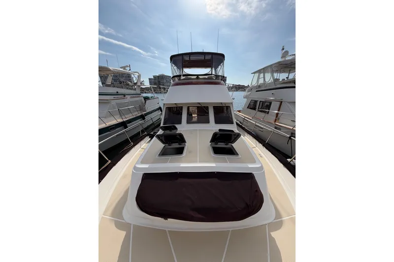 Slide: The Image of 1988 Offshore Yachts 48 Sedan docked, showcasing sleek design and spacious deck. - 14