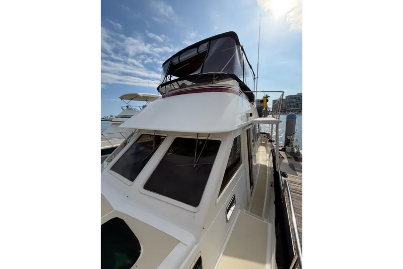 Slide: The Image of 1988 Offshore Yachts 48 Sedan docked under a sunny sky. - 15