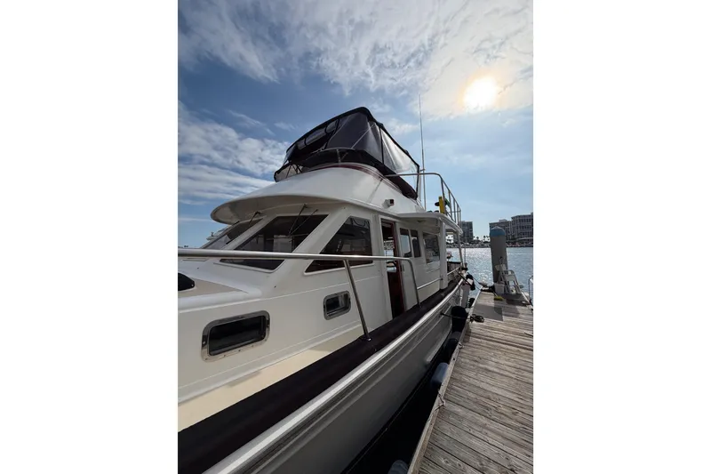 Slide: The Image of 1988 Offshore Yachts 48 Sedan docked under a sunny sky. - 3