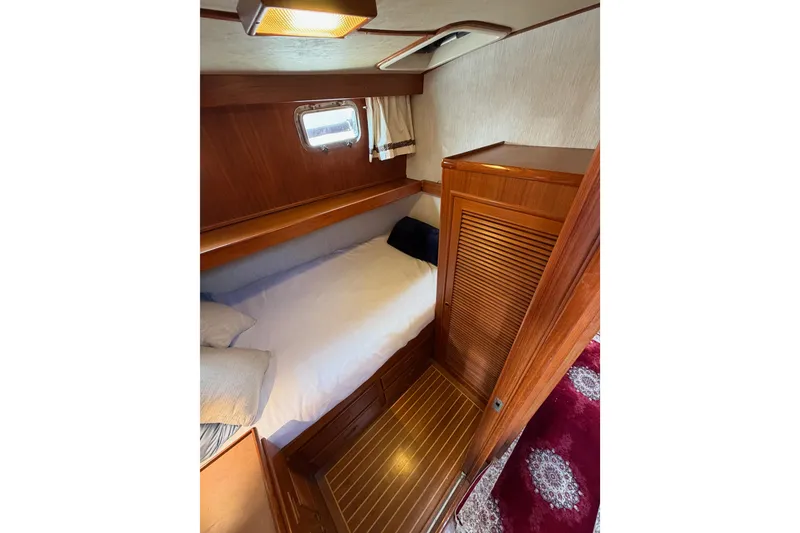 Slide: The Image of Cozy cabin interior of 1988 Offshore Yachts 48 Sedan with wooden finishes and bedding. - 58