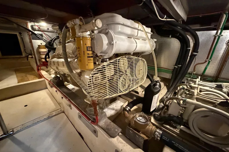 Slide: The Image of Engine room of 1988 Offshore Yachts 48 Sedan, showcasing mechanical components and wiring. - 76