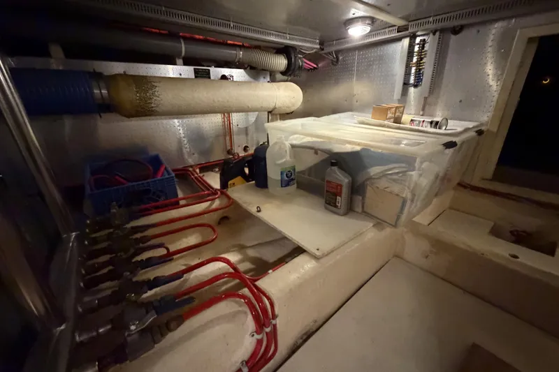 Slide: The Image of Engine room of 1988 Offshore Yachts 48 Sedan with storage and maintenance supplies. - 82
