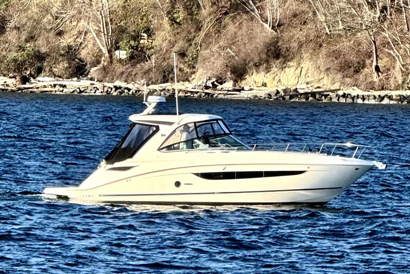 The Image of 2021 Sea Ray Sundancer 350 cruising on a scenic lake with rocky shoreline. - 0