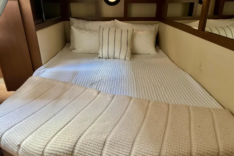 Slide: The Image of Cozy cabin bed in 2021 Sea Ray Sundancer 350 yacht with white bedding and pillows. - 11