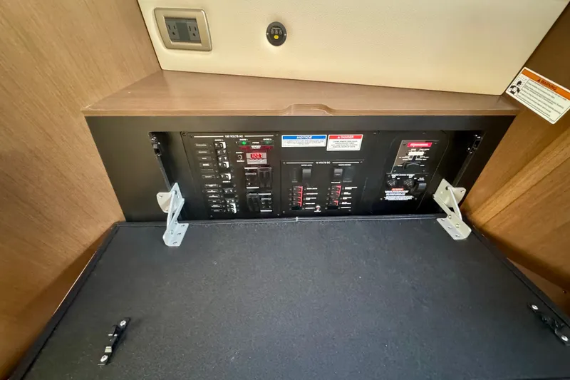 Slide: The Image of Electrical panel inside 2021 Sea Ray Sundancer 350 boat, featuring circuit breakers and outlets. - 19