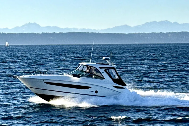 Slide: The Image of 2021 Sea Ray Sundancer 350 cruising on open water with mountains in the background. - 20