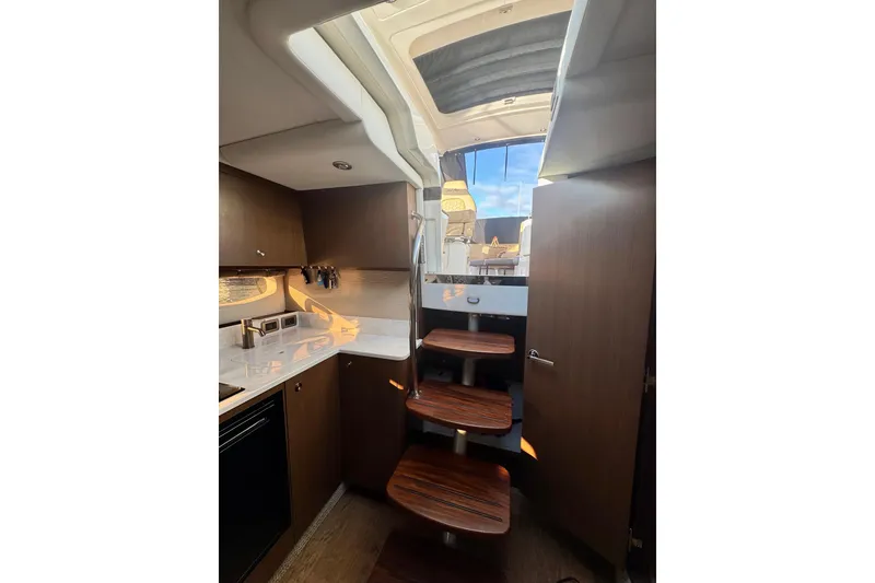 Slide: The Image of Interior of 2021 Sea Ray Sundancer 350 yacht with modern kitchen and wooden stairs. - 21