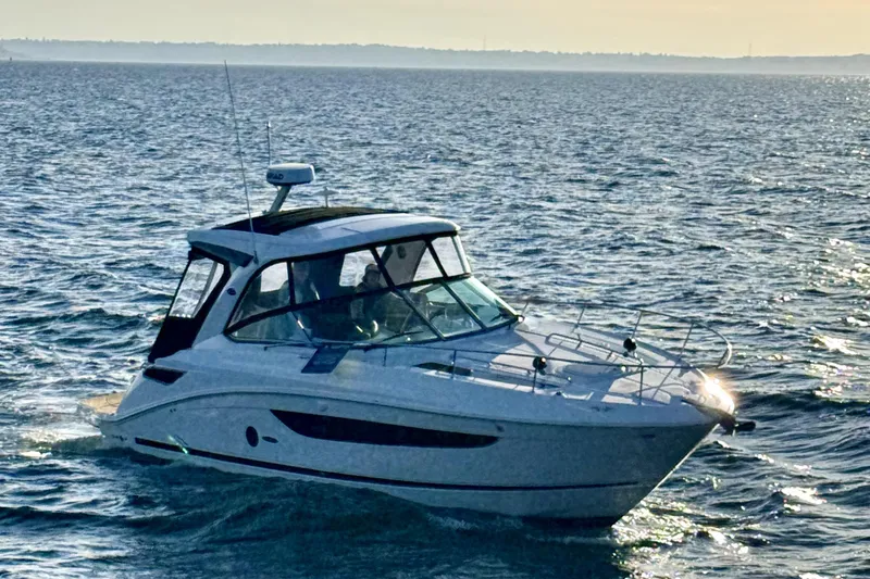 Slide: The Image of 2021 Sea Ray Sundancer 350 cruising on open water at sunset. - 25