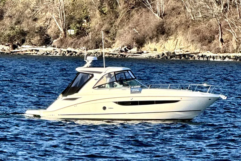 Slide: The Image of 2021 Sea Ray Sundancer 350 cruising on a scenic lake with rocky shoreline. - 29