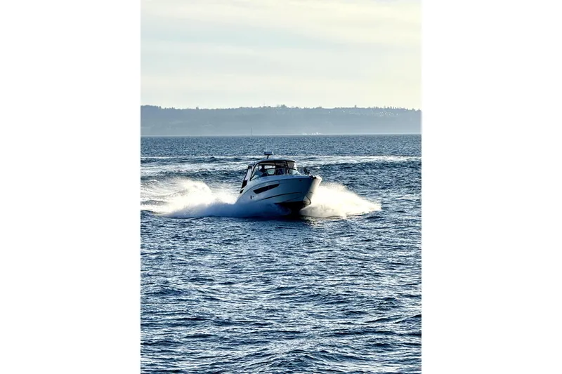 Slide: The Image of 2021 Sea Ray Sundancer 350 cruising on open water, creating a dynamic wake. - 32