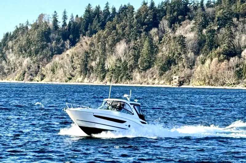 Slide: The Image of 2021 Sea Ray Sundancer 350 cruising on a scenic lake with forested shoreline. - 37
