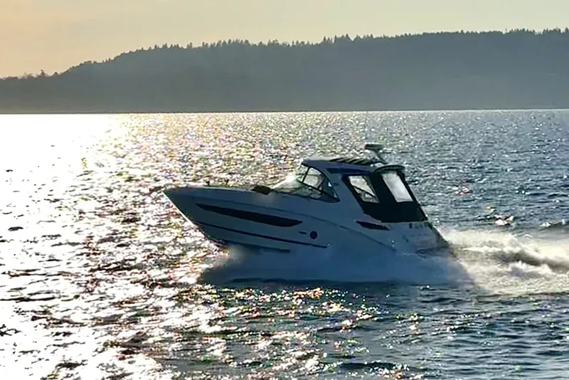 Slide: The Image of 2021 Sea Ray Sundancer 350 cruising on a sunlit lake with scenic background. - 38
