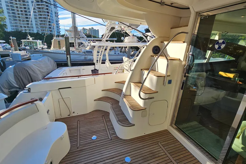 Slide: The Image of 2005 Prestige 46 yacht cruising with passengers on deck in a scenic waterfront setting. - 10