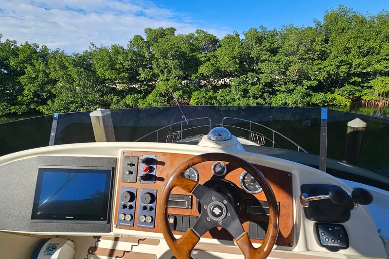 Slide: The Image of 2005 Prestige 46 yacht docked, surrounded by other boats, under clear blue sky. - 13