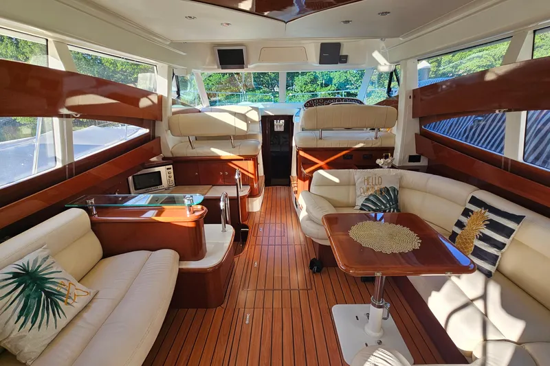 Slide: The Image of 2005 Prestige 46 yacht deck with wooden flooring and elegant seating area. - 14