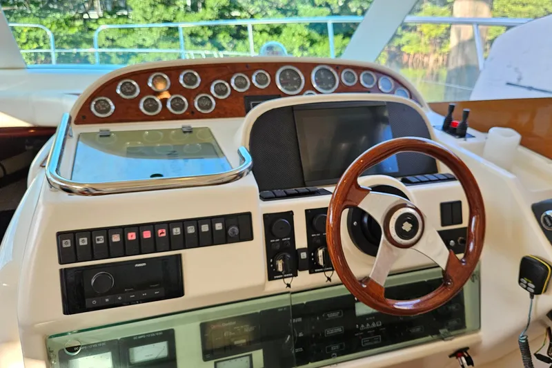 Slide: The Image of Flybridge of 2005 Prestige 46 yacht with seating and table, docked near other boats. - 17