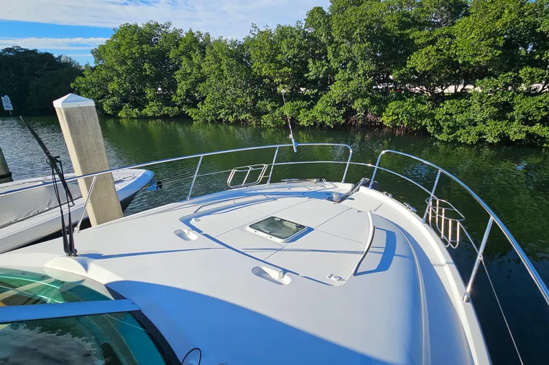 Slide: The Image of 2005 Prestige 46 yacht cruising near urban waterfront with high-rise buildings. - 5