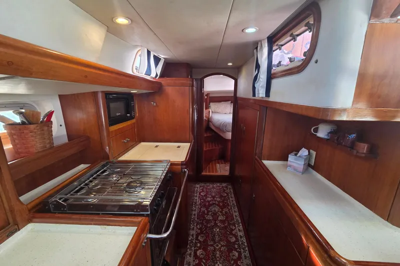 Slide: The Image of Interior of 1998 Oyster 485 Deck Saloon with navigation equipment and wooden furnishings. - 12
