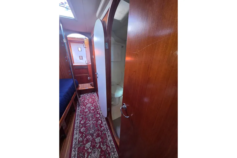 Slide: The Image of Interior of 1998 Oyster 485 Deck Saloon yacht with wooden finishes and cozy sleeping area. - 21