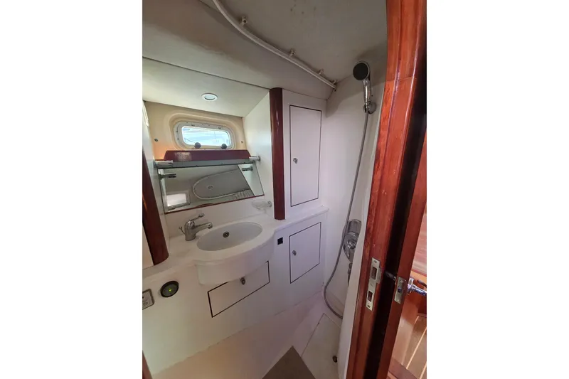 Slide: The Image of Interior of 1998 Oyster 485 Deck Saloon with wooden bunk beds and skylight. - 22
