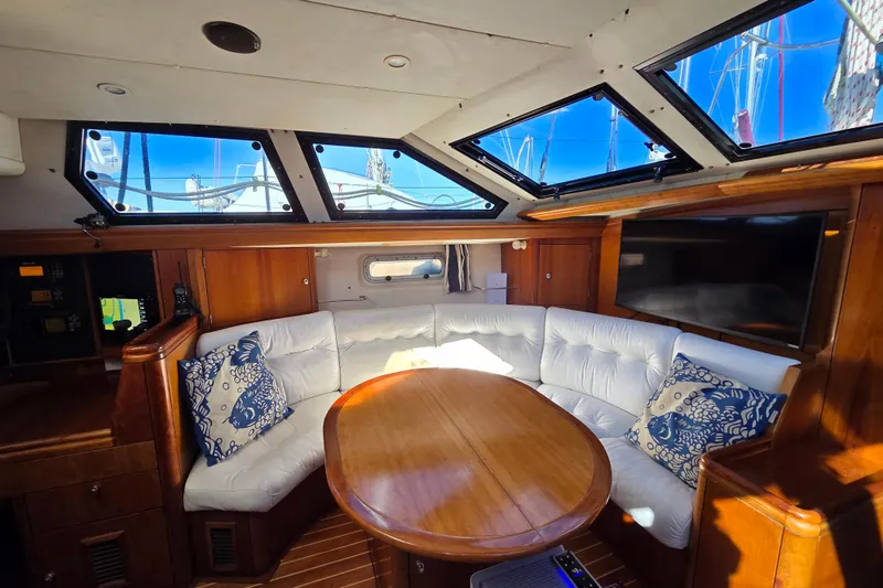 Slide: The Image of Luxurious interior of 1998 Oyster 485 Deck Saloon with white seating and wooden table. - 5