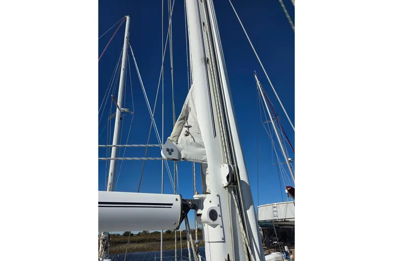 Slide: The Image of Oyster 485 Deck Saloon 1998 sailboat with "PEMAQUID" on the boom under clear blue sky. - 50