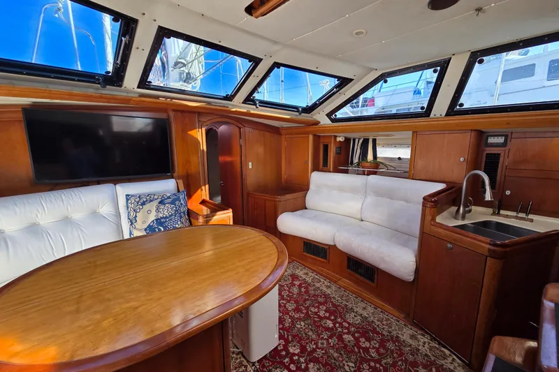 Slide: The Image of Interior of 1998 Oyster 485 Deck Saloon yacht with white sofa and kitchenette. - 6