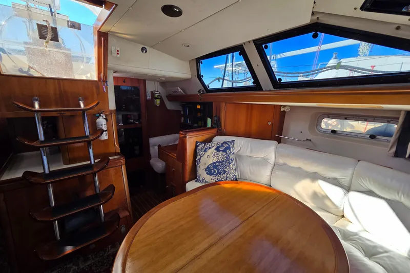 Slide: The Image of Luxurious interior of 1998 Oyster 485 Deck Saloon yacht with white seating and wooden table. - 7