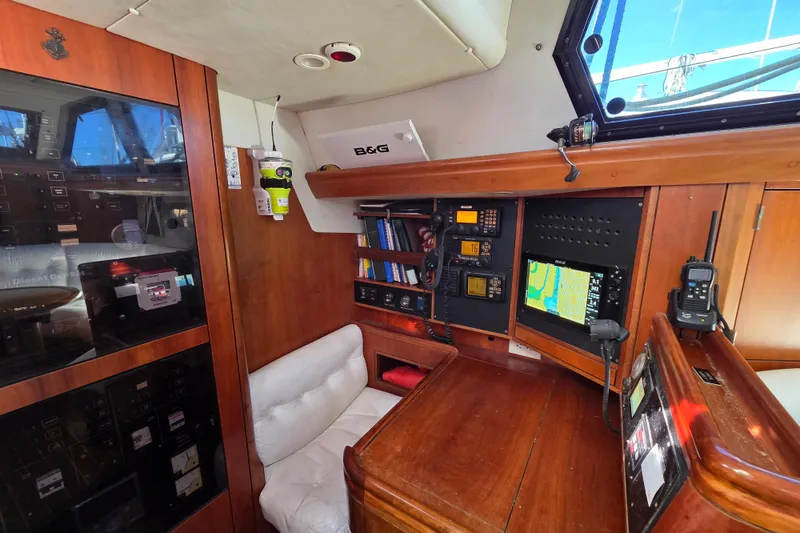 Slide: The Image of Luxurious interior of 1998 Oyster 485 Deck Saloon yacht with white seating and wooden finishes. - 8