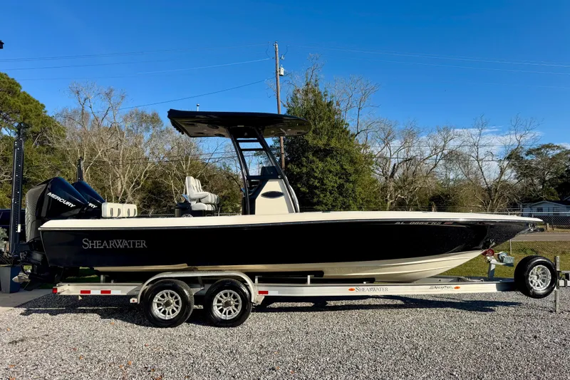 Slide: The Image of 2021 ShearWater 27 Carolina boat on trailer, parked outdoors, clear sky background. - 2