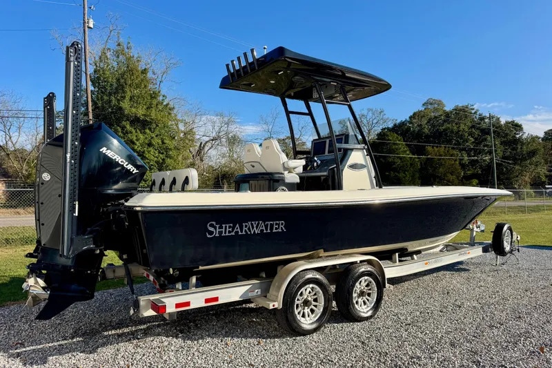 Slide: The Image of 2021 ShearWater 27 Carolina boat on trailer, featuring Mercury engine, parked outdoors. - 3