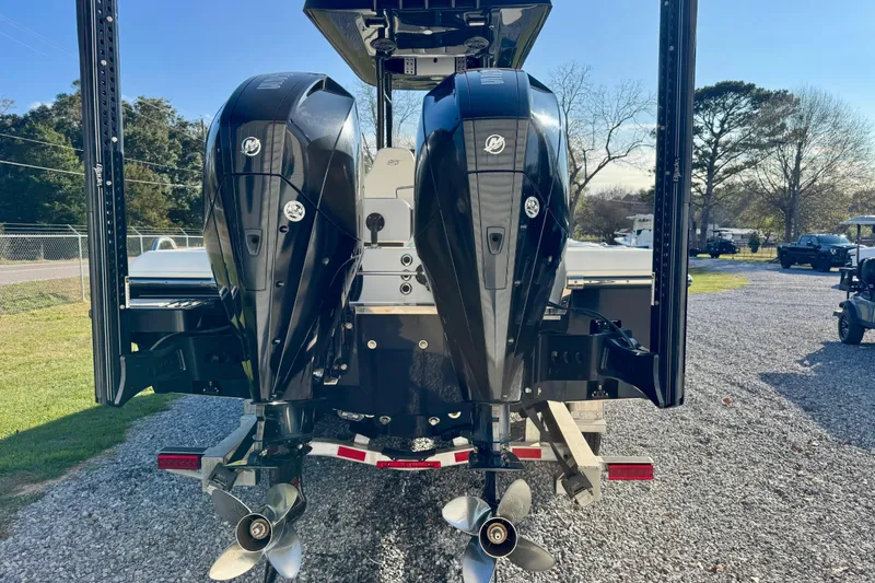 Slide: The Image of 2021 ShearWater 27 Carolina boat with dual outboard engines on a gravel lot. - 4