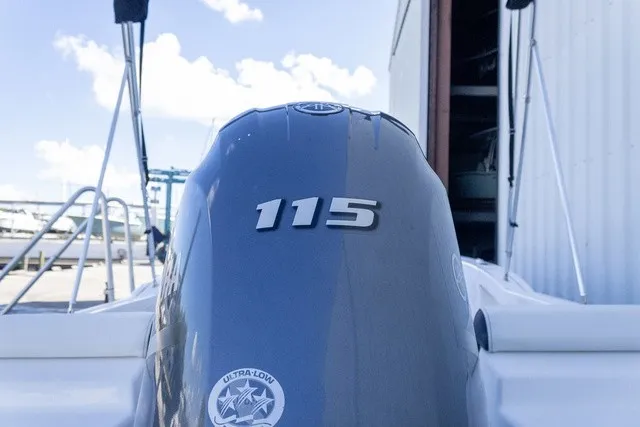 Slide: The Image of An outboard motor labeled "115" is mounted on a boat. The sky is clear. - 11