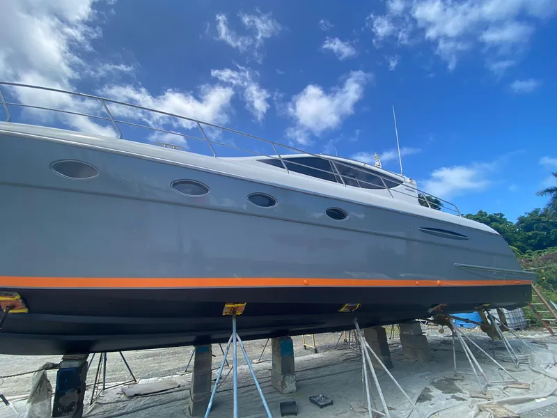 Slide: The Image of 2007 Uniesse 54 Sport yacht on dry dock under a clear blue sky. - 2